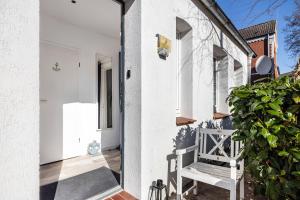 a white house with a bench on the front porch at Ferienwohnung Gartencity in Geesthacht
