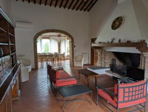 a living room with red chairs and a fireplace at Tenuta Di Monaciano in Ponte A Bozzone