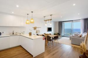 a kitchen and living room with a table and a couch at Casa Castanheta in Câmara de Lobos