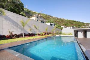 a swimming pool in front of a building at Casa Castanheta in Câmara de Lobos