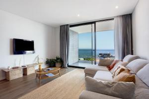 a living room with a couch and a large window at Casa Castanheta in Câmara de Lobos