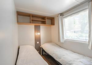 a small room with two beds and a window at Mh324 La Tremblade in La Tremblade
