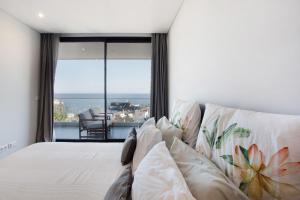 a bedroom with a bed with a large window at Casa Castanheta in Câmara de Lobos +37 photos