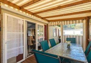 a screened porch with a table and chairs at Mh324 La Tremblade in La Tremblade +3 photos