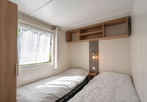 a small room with two beds and a window at Mh324 La Tremblade in La Tremblade