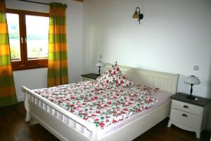 a bedroom with a white bed with a floral bedspread at Haus Leenja in Beverungen