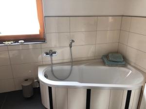 a bath tub with a shower in a bathroom at Haus Leenja in Beverungen +23 photos
