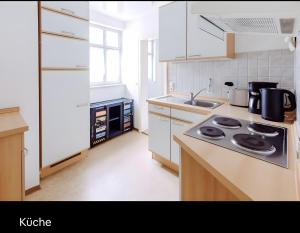 a kitchen with a stove top oven next to a sink at Fewo Forchheim in Forchheim