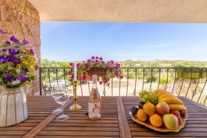 a table with a plate of fruit and a bottle of wine at Casa Valeria Costa Paradiso in Trinità d'Agultu e Vignola