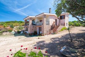 an image of a house with flowers in front of it at Casa Valeria Costa Paradiso in Trinità d'Agultu e Vignola