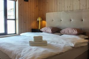 a bedroom with a large white bed with a hat on it at Beitostølens smørblomst in Beitostøl