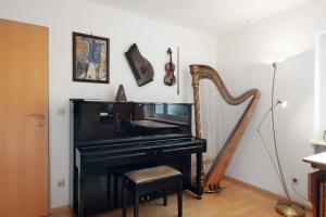 a piano and a chair in a room with a harpsichord at Secret Garden in Müllheim +21 photos