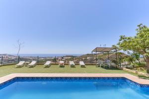 a swimming pool with chairs and a table at Villa Torrox Costa con Piscina in Torrox