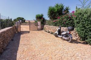 a motorcycle parked next to a stone wall at Tramonto A Nordovest in Favignana +35 photos
