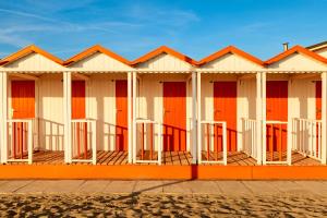 a row of orange and white beach huts at Loft parallela lungomare posto auto in Viareggio