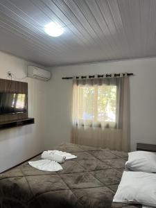 a bedroom with a large bed and a window at Pousada Centro in Gramado