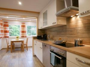 eine Küche mit weißen Schränken und einem Tisch darin in der Unterkunft Ferienwohnung Eulennest in Wolfach