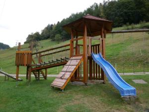 ein Holzspielplatz mit Rutsche und Spielstruktur in der Unterkunft Ferienwohnung Eulennest in Wolfach