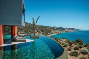 a swimming pool with a view of the ocean at River Villas Plomari - Luxury Villas with Direct Pool Access in Plomari