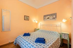 a bedroom with a bed with two blue towels on it at Atelier Lucca Centro in Lucca