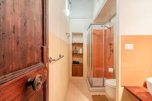 a bathroom with a shower and a wooden door at Atelier Lucca Centro in Lucca +16 photos