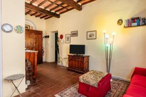 a living room with a red couch and a tv at Atelier Lucca Centro in Lucca