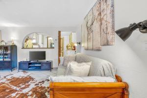 a living room with a couch and a tv at Gîte Le Montagn'art in Beauvezer