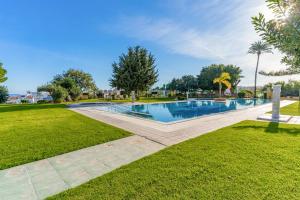 a swimming pool in a park with grass and trees at Sky Costa Del Sol in Torremolinos