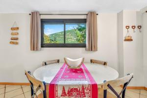 a dining room with a table and a window at Gîte Le Montagn'art in Beauvezer