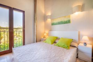a bedroom with a bed with green pillows and a window at Redonda 2 in Costitx +22 photos