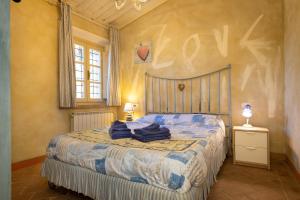 a bedroom with a bed with blue clothes on it at San Giovanni Residence in Peccioli