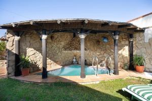 a swimming pool in a stone building with a gazebo at Villa Indie in Chiclana de la Frontera