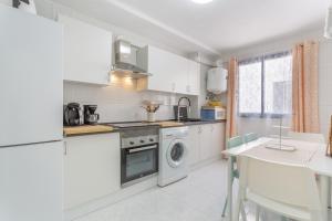 a kitchen with white appliances and a table with chairs at Retama in Adeje