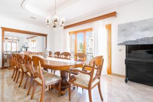 a dining room with a wooden table and chairs at Can Maro in Santa Margalida