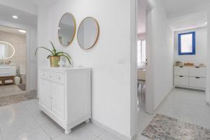 a white bathroom with two mirrors on a wall at Retama in Adeje +15 photos