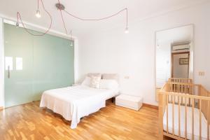 a white bedroom with a bed and a staircase at Can Maro in Santa Margalida