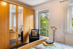 a bedroom with a bed and a chair and a window at Ferienwohnung Tannenblick 6-1 in Oberhof