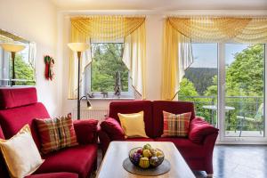 a living room with red couches and a table at Ferienwohnung Tannenblick 6-1 in Oberhof