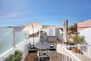 a balcony with a table and an umbrella at Casa Doce in Silves