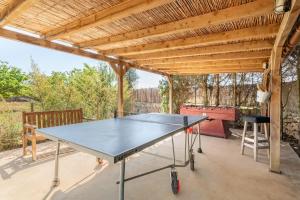 a ping pong table on a patio with a wooden roof at Es Lledoner 2 in Islas Baleares