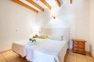a bedroom with a white bed with a plant on it at Es Lledoner 2 in Islas Baleares +16 photos