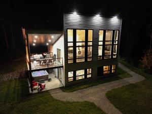 a small house at night with a lot of windows at O Vitre Spa - Relax with St-Lawrence Views in Les Éboulements