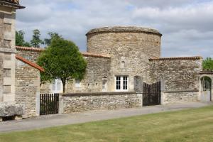 an old brick building with a black gate at Gites Du Château De Saveilles in Paizay-Naudouin