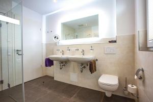 a bathroom with a sink and a toilet and a mirror at Ferienhaus Am Rösslewald in Breitnau +25 photos