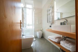 a white bathroom with a sink and a toilet at Hotel Genova Liberty in Genoa