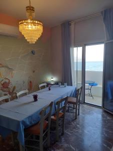 a dining room with a table and chairs and a chandelier at I have a big dream in Agia Pelagia