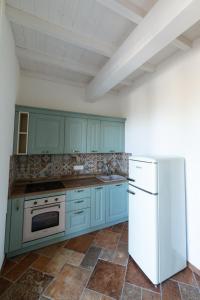a kitchen with blue cabinets and a white refrigerator at Il Timo in Marciana +16 photos