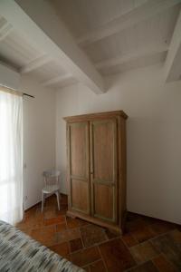 a bedroom with a wooden cabinet and a chair at Il Timo in Marciana