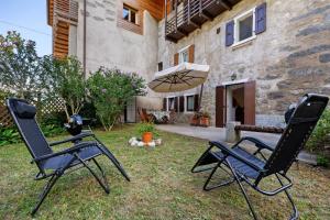 two chairs and an umbrella in front of a house at Antico Casolare di Alice in Cares