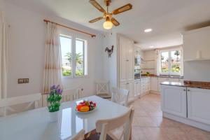 a kitchen with a white table and a ceiling fan at Villa Loli in Alcudia